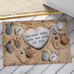 a heart - shaped rock with the words sandy feet beach is placed on a wooden floor