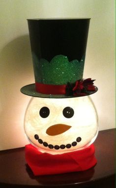 a snowman with a green top hat and red scarf on it's head