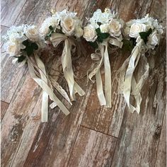 three bridal bouquets on the floor with ribbons