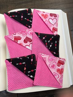 several pieces of fabric are laid out on a book with pink and black polka dots