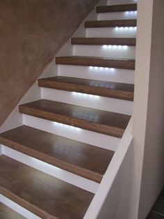 a set of stairs with lights on each side and wood treads in the middle