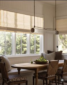 a wooden table sitting under a window in a living room