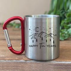 a stainless steel mug with the words happy tim years printed on it and a red handle