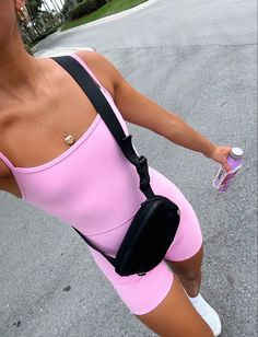 a woman in pink is holding a water bottle