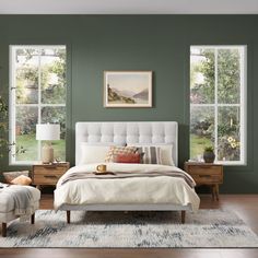 a bedroom with green walls and white furniture