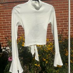 Cropped White Blouse With A Beautiful Bell Sleeve Detail, A High Neck, Featuring An Open Back With A Feminine Bow. Would Be A Perfect Statement Piece For A Date Night Outfit. Never Worn, New With Tags Still Attached. Long Sleeve Stretch Tops For Brunch, Stretch Long Sleeve Tops For Brunch, Fitted Long Sleeve Blouse For Day Out, Chic Cropped Tops For Fall, Fall Day Out Fitted Top, Fitted Crop Top For Fall Day Out, Fitted Crop Top For Day Out In Fall, Fitted Tops For Fall Day Out, Solid Cropped Blouse For Spring