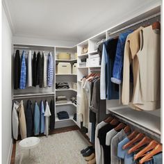 an organized closet with clothes and shoes on hangers, carpeted flooring and white walls