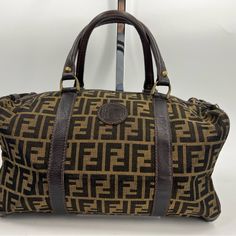 Fendi Zucca Vintage Duffle Bag Tan And Brown With Classic Fendi Print Approximately 13l X 8w X 7h Functional Zipper (With A Lock) Item Shows Signs Of Wear From Normal Use- Slight Discoloration Inside As Well As Outside Lining, Wear Of Stitching Inside, Ect. Please Refer To Photos For Further Details Sku: 2zantp82668 Pre-owned Designer Brown Bags, Pre-owned Brown Bag With Double Handle, Pre-owned Rectangular Brown Bag, Designer Pre-owned Travel Bags, Fendi Print, Fendi Bags, Travel Bags, Duffle Bag, Fendi