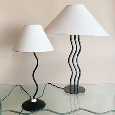 two lamps sitting on top of a glass table