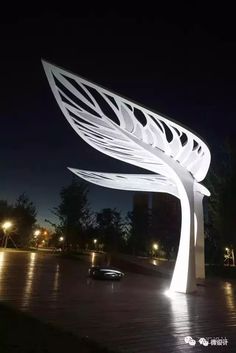 a large white sculpture sitting on top of a wooden floor next to a parking lot