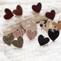 several heart shaped pins laying on top of a white blanket