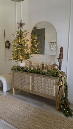 a living room with a christmas tree in the corner and decorations on the sideboard