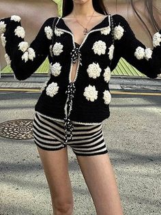 a woman in black and white is posing for the camera with her hands up to her chest