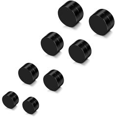 six black knobs are arranged in a row on a white surface, with one button facing the other direction