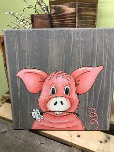 a painting of a pink pig with flowers on it's nose, sitting on a wooden table