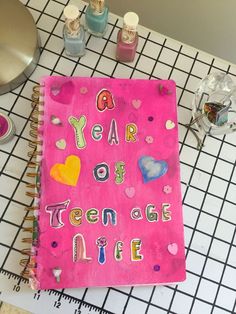 a pink notebook with the words year of teen age life written on it next to other school supplies