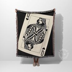 a woman is holding up a black and white blanket with an ace playing card on it