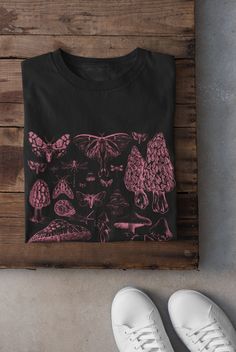 Thanks for stopping by! Pink mushrooms and moths t-shirt Printed on a super soft, cotton tee Dispatched in 5 working days or sooner Unisex Free UK delivery Material: 100% ringspun cotton. Chest (to fit): S  34/36   M  38   L  40/42   XL  44/46   XXL  48/50 ECO-FRIENDLY Each garment is made to order, reducing extra material and energy that would be otherwise wasted We use DTG printing process which is easier on the environment than screen-printing Our ink is bright and also eco-friendly. Do not t Fairy Grunge Crew Neck T-shirt With Graphic Print, Black Crew Neck Fairy Grunge Top, Black Fairy Grunge Crew Neck Top, Fairy Grunge Crew Neck T-shirt With Screen Print, Fairy Grunge Graphic Print Crew Neck T-shirt, Halloween Fairy Grunge T-shirt With Crew Neck, Fairy Grunge Halloween T-shirt With Crew Neck, Black Fairy Grunge Cotton T-shirt, Black Graphic Tee With Mushroom Print