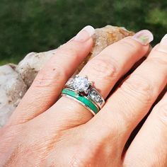 a woman's hand with two wedding rings on her left and the other hand holding a rock