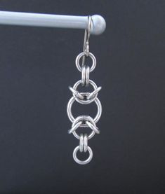 These earrings are woven together in a chainmaille pattern with stainless steel jump rings. The ear wires are hypoallergenic titanium. I think they are kind of fun and funky. They are just under 2 inches (5 cm) long, and just under 1/2 an inch (1.3 cm) wide. I have more chainmaille jewelry listed here: https://www.etsy.com/shop/BlackCatLinks/search?search_query=chainmaille&order=date_desc&view_type=gallery&ref=shop_search All of my earrings are listed here: https://www.etsy.com/shop/ Metal Earrings With Hook And Links For Gifts, Stainless Steel Chain Link Jewelry With Jump Ring, Silver Chain Link Earrings, Chainmaille Jewelry Patterns, Chainmaille Earrings, Jump Ring Jewelry, Chainmail Jewelry, Earrings Chain, Safety Pin Earrings