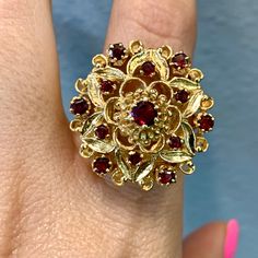 Metal: 14kt Yellow Gold                                                                                                                                                                                                                                                                                                                                Weight Of Ring Including Gems: 12.80 grams                                                                                                                                                                                                                                                                                                                                          Stone: Garnet Shape: Round Collectible Ruby Ring In Fine Jewelry Style, Collectible Fine Jewelry Ruby Ring, 14k Stamped Ruby Ring, Intricate Jewelry, Garnet Ring, Garnet Rings, Gold Floral, Rings Statement, Statement Rings