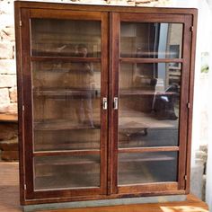 a wooden cabinet with glass doors on top