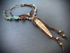 "Gorgeous hand carved fang from Tibet on a necklace of earthy jasper, turquoise and jade. Finished off with vintage chain and soft leather at the back and tied around the focal. Sliding beads in back let you adjust the length up to 5\". Measures 32\" total. Focal measures 6\"." Bohemian Adjustable Patina Necklace, Handmade Adjustable Brown Turquoise Necklace, Adjustable Brown Turquoise Bohemian Necklace, Handmade Rustic Adjustable Turquoise Necklace, Adjustable One-of-a-kind Turquoise Necklace For Festivals, Fang Necklace, Vintage Chain, Leather Jewelry, Tibet