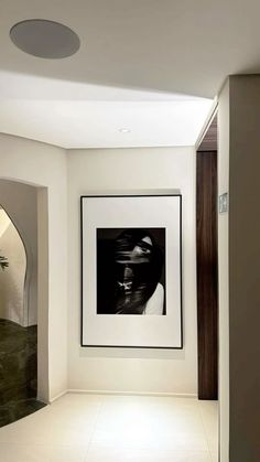 an empty room with a framed photograph hanging on the wall and a plant in the corner