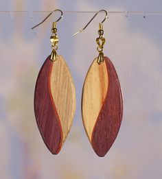 two tone wooden earrings hanging from hooks