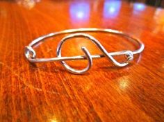 a silver bracelet sitting on top of a wooden table