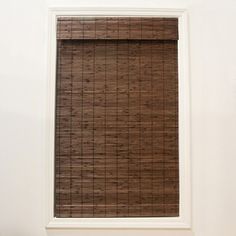 a window covered in brown blinds next to a white wall