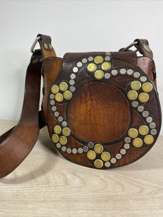 Really unique Vintage Hand Tooled hand Stitched Leather Shoulder Bag/Purse With Metal Rivets Deco Really Thick Leather boho, weight over 1lb13oz. The bag is 9" wide 8" height and 4'" deep. The strap is not adjustable. From the bottom of the bag to the far end of the strap is a little bit over 25”. There is one metal rivet missing, you can see it from the last photo, which is not effect the use of the bag. Please check all the photos for details as they are part of the description. Shipped with U Vintage Crossbody Shoulder Bag As Fashion Accessory, Vintage Brown Bags As Fashion Accessory, Vintage Brown Bag As Fashion Accessory, Bohemian Pouch Shoulder Bag With Hand-stitched Details, Brown Hippie Shoulder Bag With Adjustable Strap, Festival Bags With Removable Pouch, Artisan Hand-stitched Festival Bags, Leather Bohemian Pouch Bag, Bohemian Leather Pouch Bag