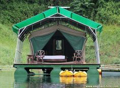 there is a tent on the water with two yellow kayaks in front of it