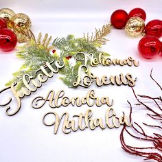 some christmas decorations and ornaments on a white surface with the words happy holidays written in cursive writing