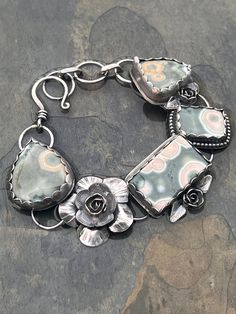 This one of a kind bracelet was made by me using four gorgeous and unique collector quality ocean jasper cabochons.  All metalwork was handmade and soldered.   I used sterling and fine silver and all metal has been oxidized for a tarnished antique look.   Adjustable from 7" up to 8.25" and can be lengthened if needed. 100% handmade down to the last jump ring Thanks for stopping by!   Feel free to contact me with any questions. ~Alisa Silver Artisan Bracelet With Cabochon, Artisan Silver Bracelet With Cabochon, Unique Sterling Silver Cuff Bracelet, Unique Sterling Silver Bracelet With Natural Stones, Artisan Sterling Silver Bracelet With Natural Stones, Silver Artisan Agate Bracelets, Artisan Silver Jasper Jewelry, Artisan Silver Agate Bracelets, Bohemian Silver Jasper Jewelry