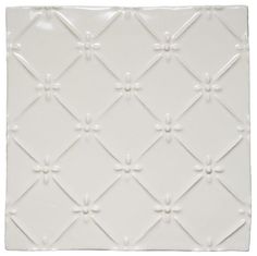 a white square tile with an intricate design