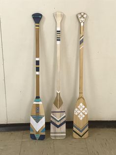 three paddles are lined up against the wall, one is made out of wood