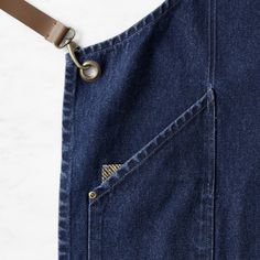 a pair of jeans with a leather belt attached to the waist and pocket, on a white surface