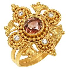 Flower shape Byzantine ring handcrafted in 22Kt yellow gold, featuring a Tourmaline center and a brilliant cut diamond in each petal. This breathtaking ring is created using the traditional techniques of filigree and granulation. Minute gold beads create the elegant shape of the flower petals while the delicate and intricate wire ornamentation transforms the gold into leaves. This unique ring belongs to Odyssea Collection: A collection inspired by the ancient Greek heritage, its timeless beauty Byzantine Ring, Byzantine Rings, Byzantine Jewelry, Choker Necklace Designs, Tourmaline Ring, Flower Ring, 22k Gold, Flower Shape, Brilliant Cut Diamond