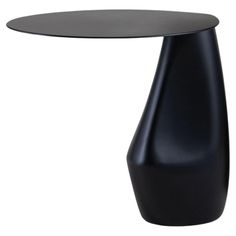 a black table with a round top and an oval shaped base on the bottom, sitting in front of a white background