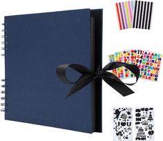 a blue notebook with black ribbon and stickers on the cover, next to it's contents