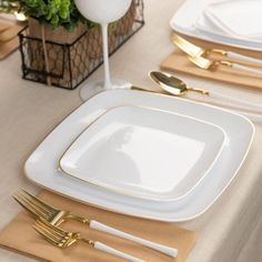 a table set with gold and white plates, silverware and napkins on it