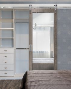 a bedroom with a bed, dresser and closet doors that have sliding glass doors on them