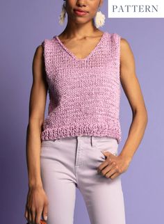 a woman is wearing a pink sweater and white pants with her hands on her hips