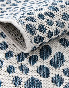 a close up view of the blue and white pattern on a rug with woven edges