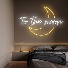 a bed with a neon sign above it that says to the moon on the wall