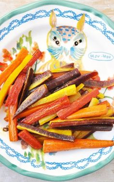 carrots and beets on a plate with an owl figurine