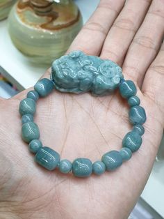 "17 pieces, Type A natural Jadeite beads (all non-bleached, non-dyed, non-treated) of blue color, glossy, semi-translucent, 9 mm (barrel) and 7 mm (round) in sizes. Jade Pixiu is also Type A, natural Jadeite, glossy, semitranslucent, marbled blue color and bears the Money / Coin symbol on the back; 4 cm x 2.5 cm x 1.4 cm. Whole bracelet weighs 50 grams. Bracelet size is set at 17 cm but in case it needed downsizing or resizing (up to 19 cm) just let us know immediately after payment by messaging us at \"Message Seller\" under the listing title. Bracelet also comes with extra sets of elastic strings, an open wire and 4 pcs of spare Jade beads (2 barrels, 2 rounds) (on top of size 17 cm)." Blue Jade Spiritual Bracelets, Spiritual Blue Jade Bracelets, Blue Jade Hand-strung Jewelry, Blue Jade Beaded Bracelet For Healing, Handmade Blue Jade Beaded Bracelet, Blue Jade Bracelets With Natural Stones, Blue Jade Beaded Bracelets For Healing, Blue Jade Bracelets For Healing, Handmade Blue Jade Beaded Bracelets