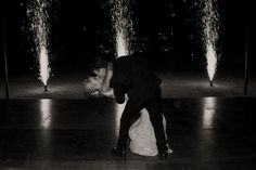 a bride and groom kissing in front of water fountains