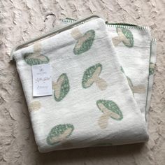 two cloths with green leaves on them sitting next to each other